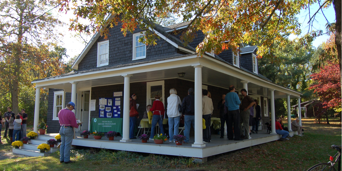 Group of people congregating on the Crawford House's porch for an open house on a fall day